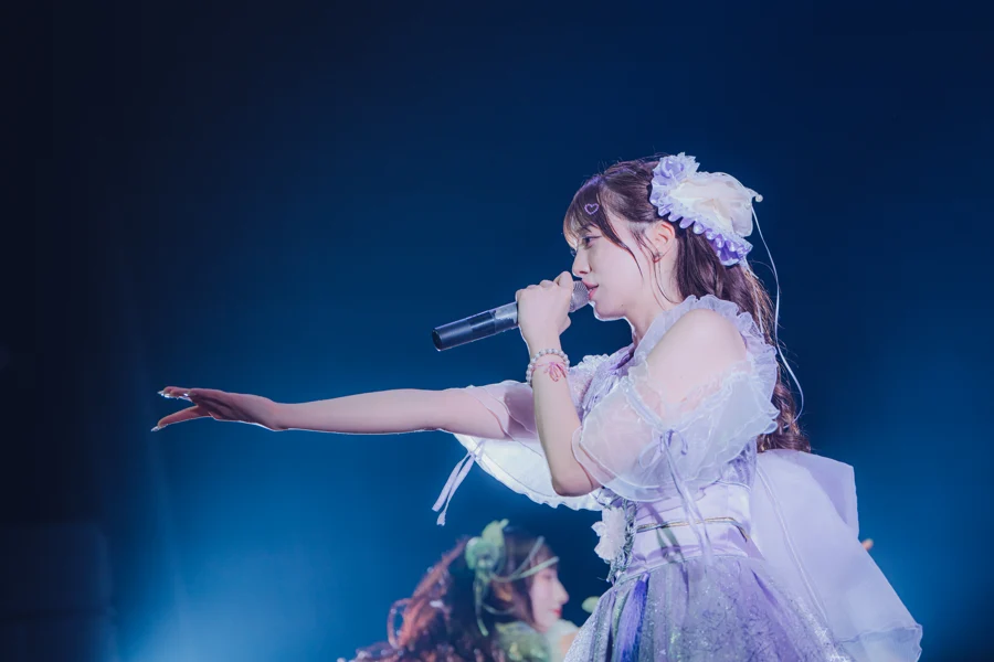 ステージで歌いながら手を伸ばすSAKURADOLLのメンバー